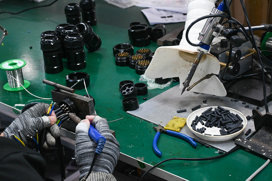 A technician soldering a socapex cable